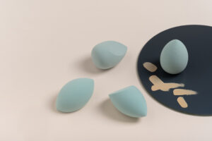 blue cosmetic makeup sponge on a beige nude background. A set of sponges of different shapes. Tool for applying foundation smears. Nobody. Beauty and fashion concept, make-up artist.