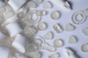 A top view of white coconut jellies with marshmallows on a white background