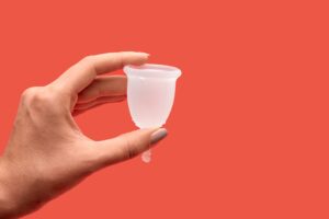 Woman hands holding menstrual cup in heart shape. Personal care ecology products