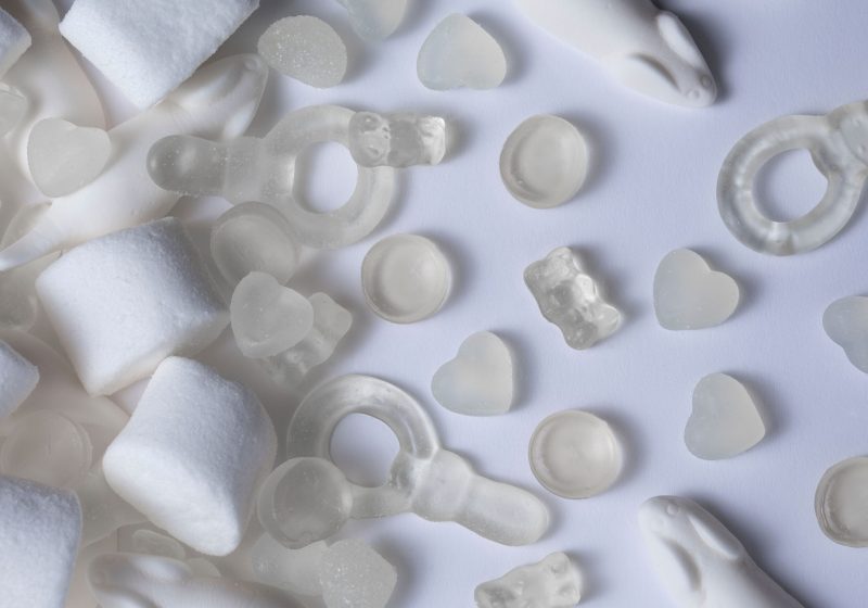 A top view of white coconut jellies with marshmallows on a white background